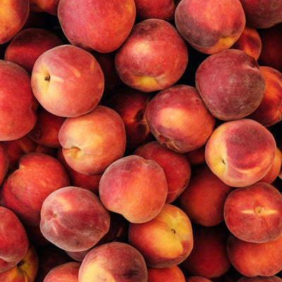 Close-up of a pile of ripe red and yellow peaches